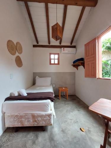 1 dormitorio con 2 camas en una habitación con mesa en Vila Alta Caraíva, en Caraíva
