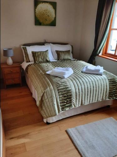 a bedroom with a bed with two towels on it at The Lake House in Drumshanbo
