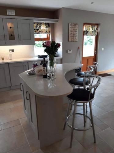 a kitchen with a large island with bar stools at The Lake House in Drumshanbo