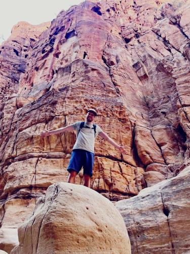 a man standing on a rock in front of a mountain at - Trekking from Dana to Petra in Dana