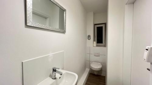 ein weißes Bad mit einem Waschbecken und einem WC in der Unterkunft Work&Stay - City nah in Neumünster