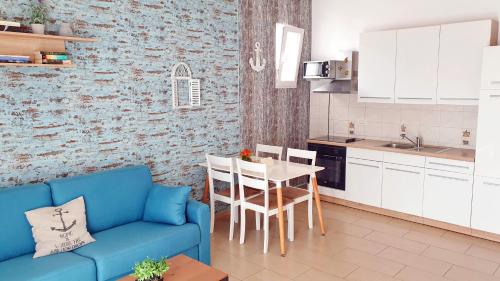a living room with a blue couch and a kitchen at Apartments Epulon in Pula