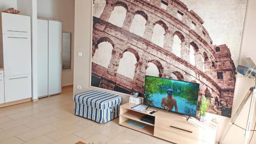 a living room with a tv and a brick wall at Apartments Epulon in Pula