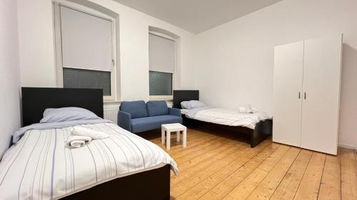 1 Schlafzimmer mit 2 Betten und einem blauen Stuhl in der Unterkunft Work&Stay - City nah in Neumünster