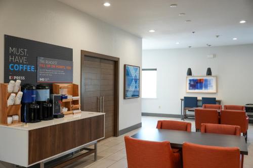 a coffee shop with a table and orange chairs at Holiday Inn Express Hotel & Suites Cedar Hill by IHG in Cedar Hill