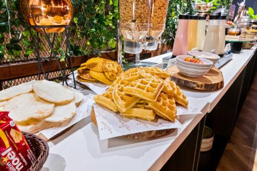 a buffet with waffles and bread and other foods at GHL Hotel Portón Medellín in Medellín