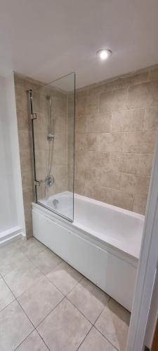 W łazience znajduje się prysznic i wanna. w obiekcie Paramount nest w mieście Swindon