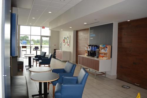 - une salle d'attente avec des tables et des chaises bleues dans l'établissement Holiday Inn Express & Suites - Liberal, an IHG Hotel, à Liberal