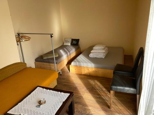 a room with two beds and a table and a chair at zielonapogoda in Lądek-Zdrój