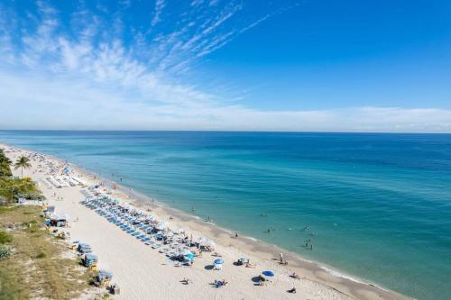 una playa con muchas sombrillas y el océano en Beachwalk Resort & Condos, en Hallandale Beach