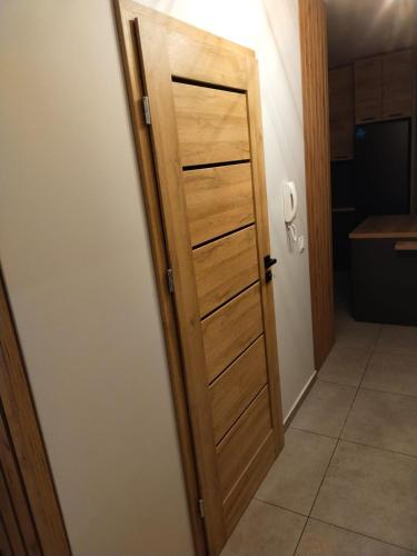 a wooden door in a room with a kitchen at Prawnicza50 in Żory
