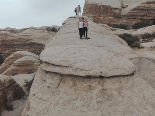 two people standing on top of a large rock at - Trekking from Dana to Petra in Dana