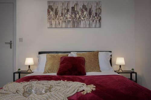 Una cama con una manta roja y gafas. en King Sized Luxury - Stylish Studio Flat en Blackpool