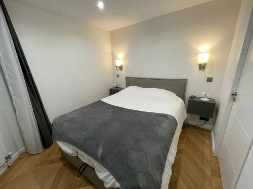 um pequeno quarto com uma cama e duas mesas de cabeceira em Appartement moderne de 2 pièces em Suresnes