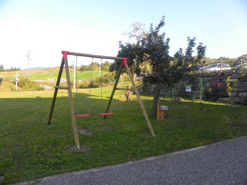 a park with a swing set in the grass at La Castagna Matta in Albareto