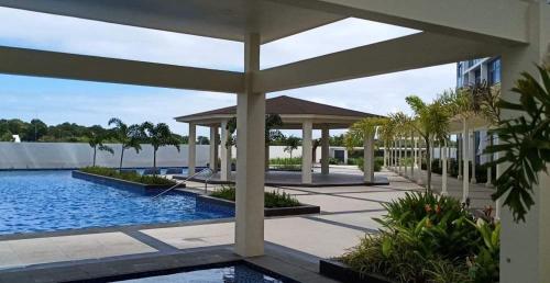 a pool with a gazebo next to a building at Mactan Cebu Beach Condo in Punta Engaño