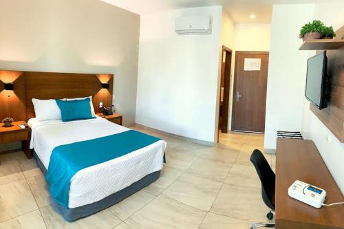 Habitación de hotel con cama, escritorio y TV. en los rafeles 5 en Guaymas