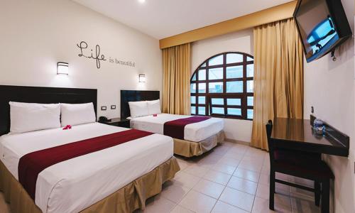 Habitación de hotel con 2 camas y TV de pantalla plana. en los rafeles 5 en Guaymas