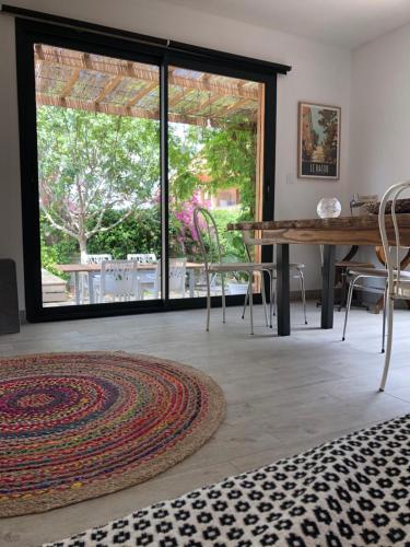 d'un salon avec une table et une grande porte coulissante en verre. dans l'établissement La Casa Del Racou, à Argelès-sur-Mer