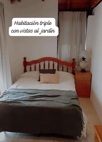 a bed with a wooden headboard in a bedroom at Lodge de Montaña in El Challao
