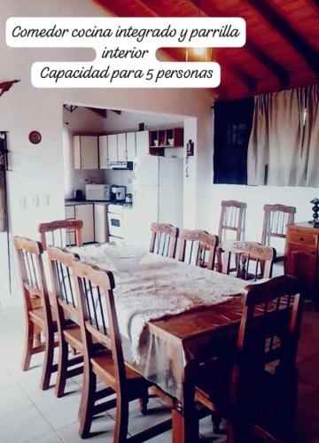 una cucina con tavolo in legno e sedie intorno di Lodge de Montaña a El Challao