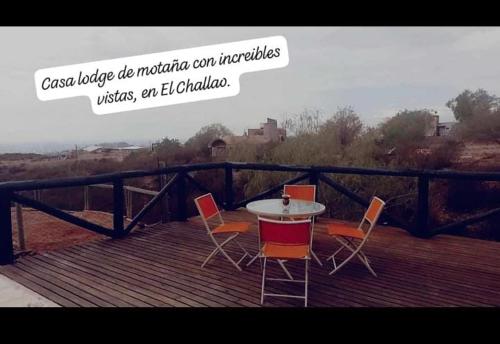 un tavolo e sedie seduti su una terrazza in legno di Lodge de Montaña a El Challao