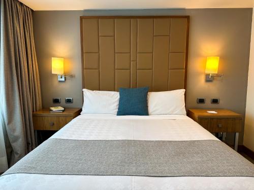 a bedroom with a large bed with two lamps at Wyndham Garden Quito in Quito