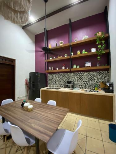 a dining room with a wooden table and white chairs at Departamento catalina in Mérida