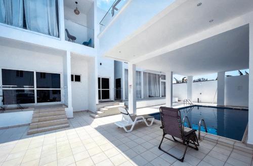 a house with a swimming pool and a patio at The Vittins in Accra