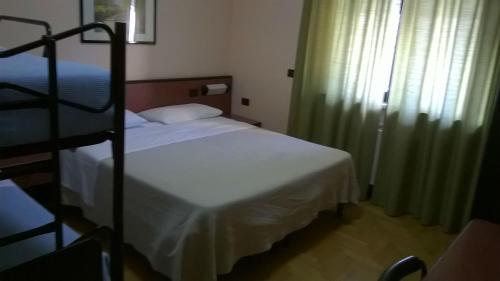 a small bedroom with a bed and a window at Hotel Du Parc in Atri