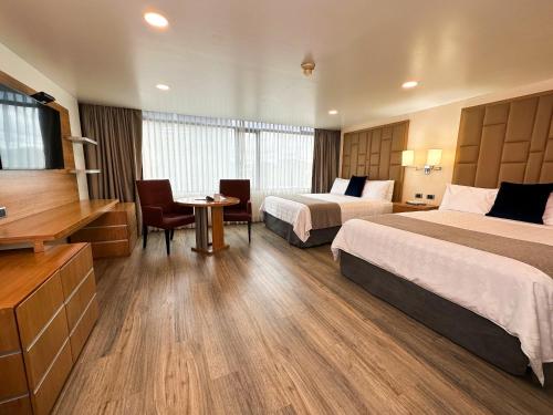 a hotel room with two beds and a television at Wyndham Garden Quito in Quito