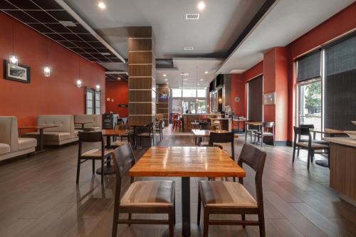 a restaurant with wooden tables and chairs and red walls at Holiday Inn Houston Downtown by IHG in Houston