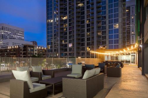 - un toit-terrasse avec des chaises, des tables et des bâtiments dans l'établissement Holiday Inn Houston Downtown, an IHG Hotel, à Houston