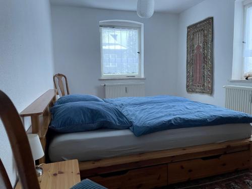uma cama com almofadas azuis num quarto em Natur pur im Erzgebirge em Breitenbrunn