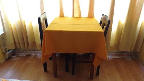 a table with a yellow table cloth on it at Hostal San Antonio in Chimbote