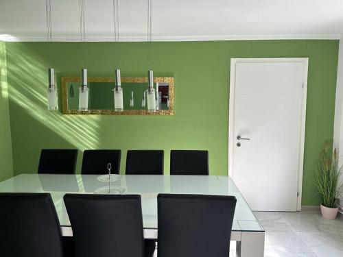 a green dining room with a table and chairs at Outlet Center House, Pool-Jacuzzi-Garden-Sundeck in Parndorf