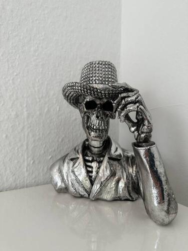 a statue of a skeleton wearing a hat with a microphone at Outlet Center House, Pool-Jacuzzi-Garden-Sundeck in Parndorf