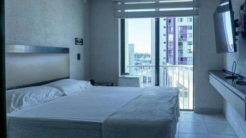 een slaapkamer met een bed en een groot raam bij Departamentos centricos en guadalajara in Guadalajara