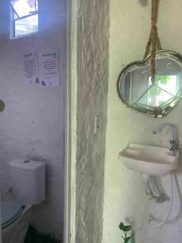 a bathroom with a sink and a toilet and a mirror at Hostel Flor da Vida in Canoa Quebrada