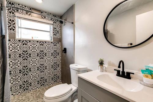 La salle de bains est pourvue de toilettes, d'un lavabo et d'un miroir. dans l'établissement Spacious 2 BR near Miami Airport Virg 5, à Miami