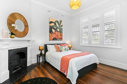 a white bedroom with a bed and a fireplace at EDW19 - Stylish 2-Bed, 2-Bath Townhose in Drummoyne in Sydney
