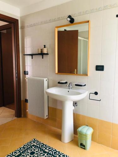a bathroom with a sink and a mirror and a radiator at Alloggio ai piedi del Cansiglio 