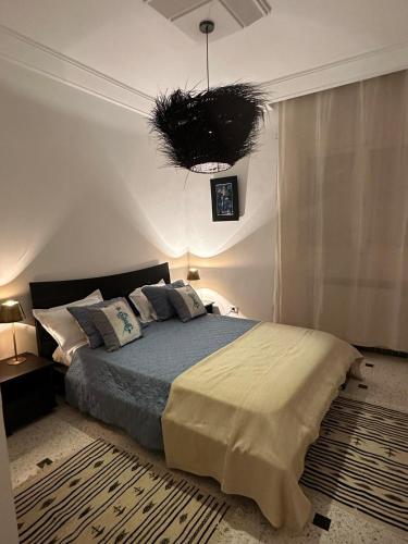 a bedroom with a bed and a pendant light at Luxeux et Idéal à Marsa Plage vue sur Mer in La Marsa