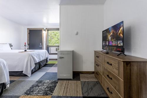 a bedroom with a bed and a television on a dresser at Copperhead Lodge in Anaconda