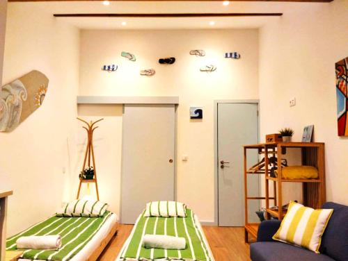 a living room with two beds and a blue couch at Maria Surfista_ As Três Marias in Matosinhos