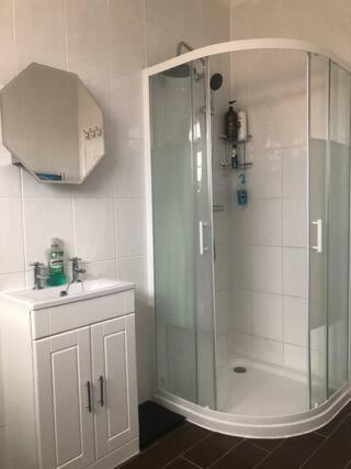 baño blanco con ducha y lavamanos en Thembile House, en Thornaby on Tees