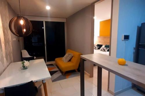 uma sala de estar com uma mesa e uma cadeira amarela em Lujoso Apartaestudio em Ibagué