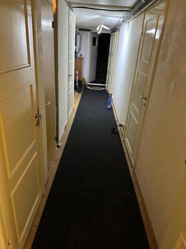 a long hallway with doors and a carpet at Room A in Malmö