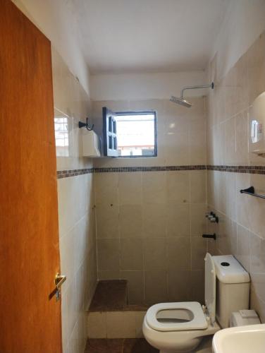 a bathroom with a toilet and a sink and a window at Casa la bendecida II in Santiago del Estero