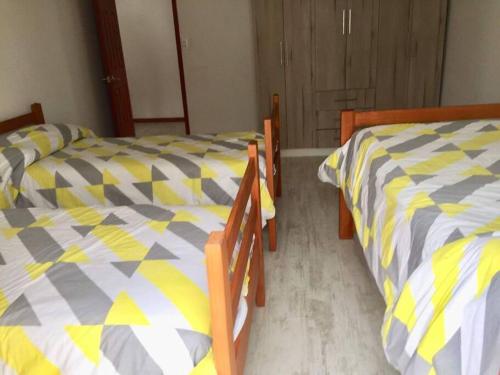 dos camas sentadas una al lado de la otra en un dormitorio en Casa de dos pisos a pasos de la playa, en Caldera